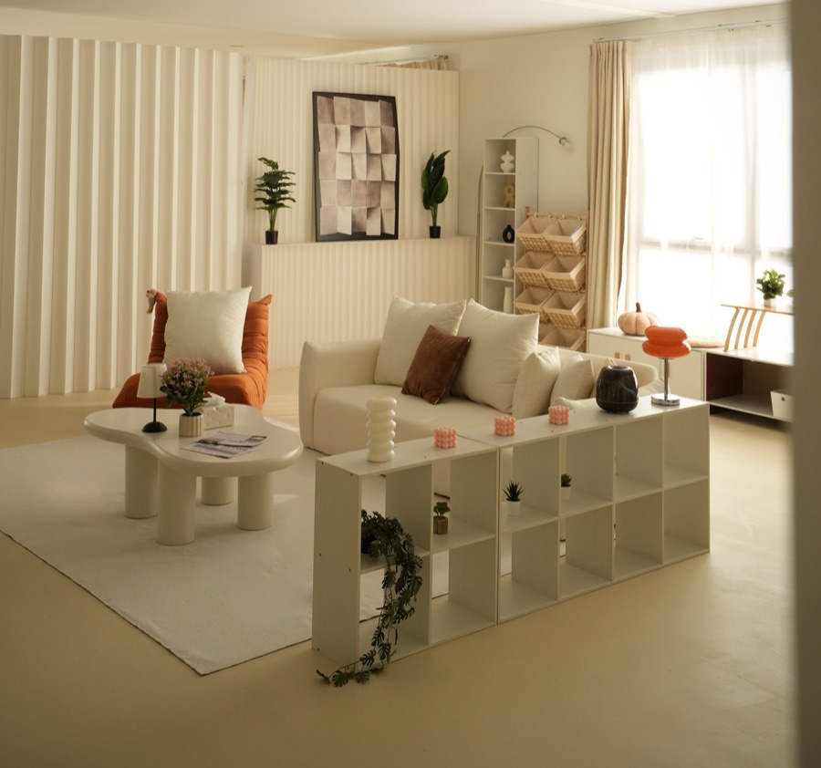 Open view of the studio: fluted wall, sofa, shelving and the window wall