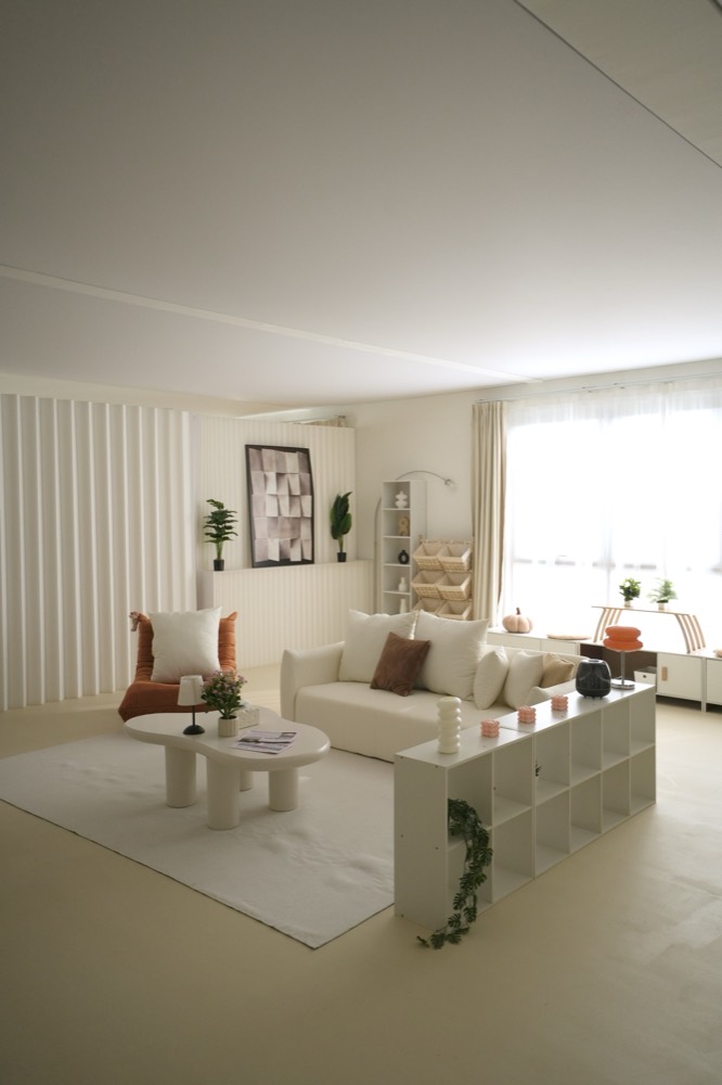 The living set with a cream sofa, cloud coffee table, shelving and the fluted wall