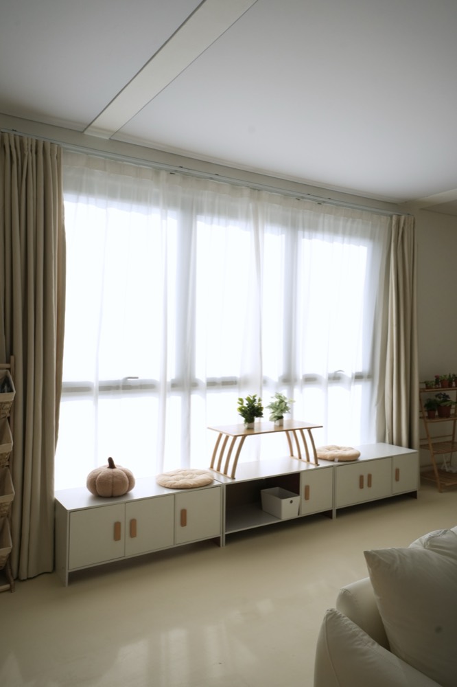 Wide sheer windows with a low white cabinet below
