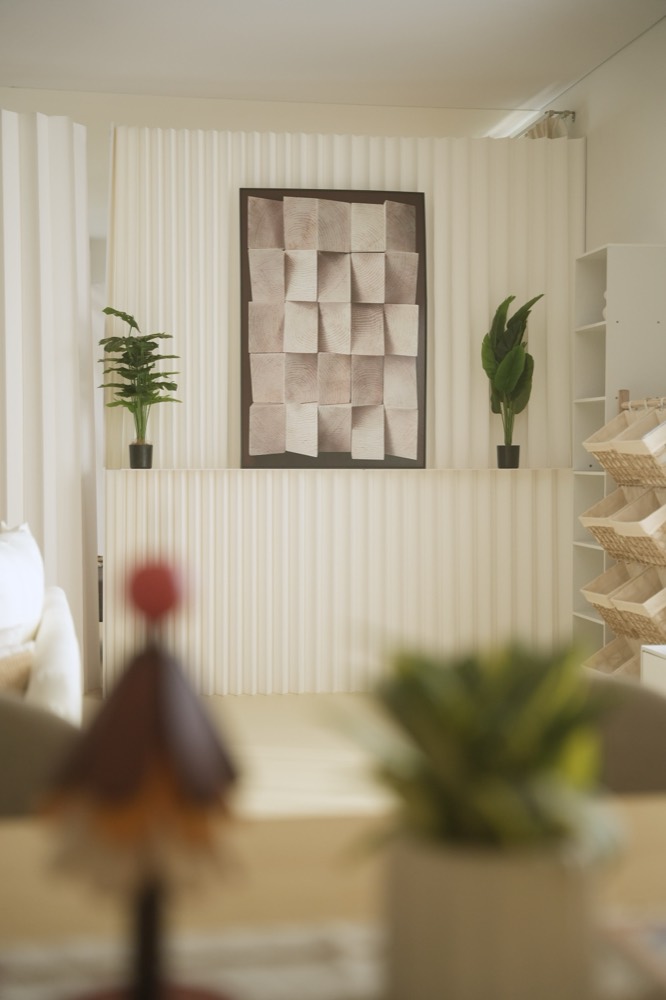 Textured art piece on the fluted wall panel with plants