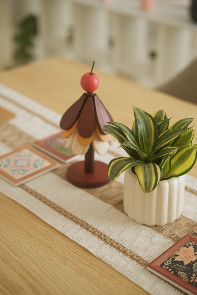 Close-up of a table runner, plant and small decorative props